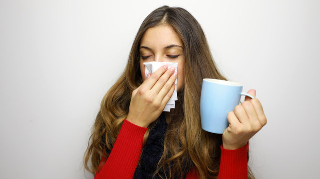 Young woman sick with cold or flu drinks something hot