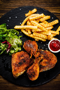 Grilled chicken legs with french fries and vegetables