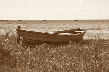 Old wooden boat on the lake bank