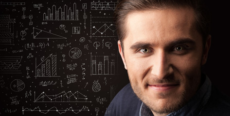 Portrait of a young businessman with charts and graphs scribbled next to him on a dark background