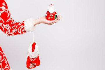 Christmas, celebration, people concept - Close up of woman's hand holding a Santa figurine on white background