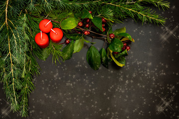 Christmas decorations with small red berries, bright balls, red candles and a pine branch on a...