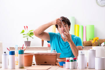 Young man decorating pottery in class