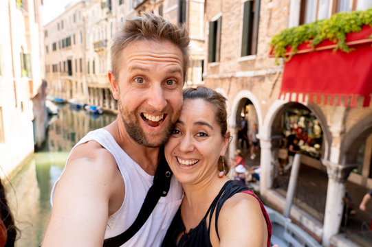 Sweet couple in love taking a selfie in Venice Italy while traveling around europe