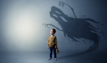 Scary ghost shadow in a dark empty room with a cute blond child
