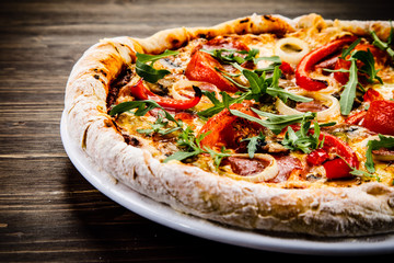 Pizza with pepper,salami and champignon on wooden table
