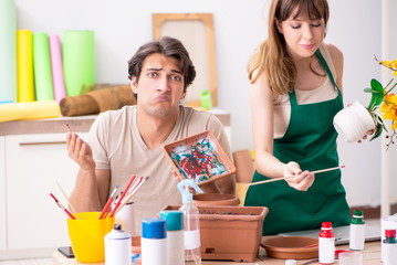 Couple decorating pots in workshop during class