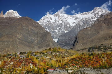Colorful Hunza valley in autumn with snow capped Ultar sar, Hunza peak and Ladyfinger peak mountains in Karakoram range. Gilgit-Baltistan, Pakistan.