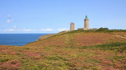 Fototapeta na wymiar Old lighthouse and flowers at Cap Frehel, Brittany. English Channel.