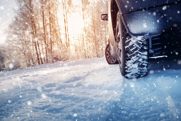 Car tires on winter road covered with snow. Snowy landscape with a vehicle