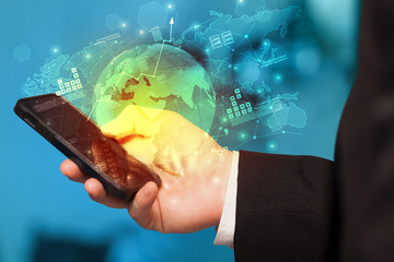 Hand using phone with global reports and stock market change concept
