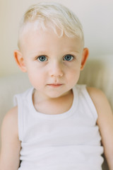 Naklejka premium Portrait of adorable little boy sitting on a sofa