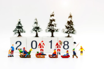 Miniature people: Childrens playing fun with snow slider.