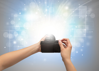 Naked hand taking picture with digital camera and glowing flash concept
