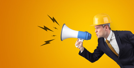 Fototapeta premium Young architect constructor yelling with megaphone and copyspace