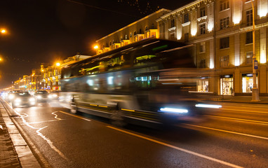 Fototapeta na wymiar The motion of a blurred bus on the avenue in the evening.