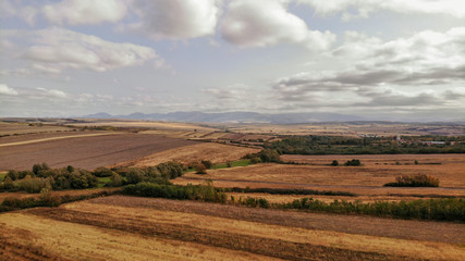 Aerial view of countryside in autumn with yellow fields and clouds in the background