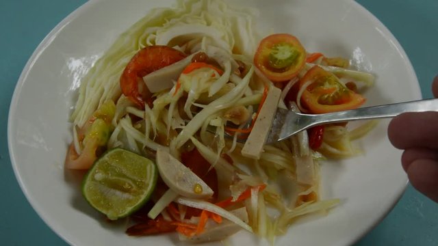 Som tum Thai spicy green papaya topping slice Vietnamese sausage salad scooping by fork