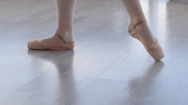 female legs close up. ballerina in pointe kneads the foot before the performance. The girl gets up on her socks. HD Slow motion