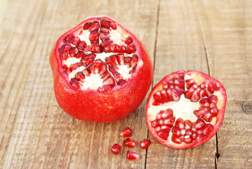 Pomegranate fruit isolated. Pomegranate grains. Pomegranate close up on wooden table.