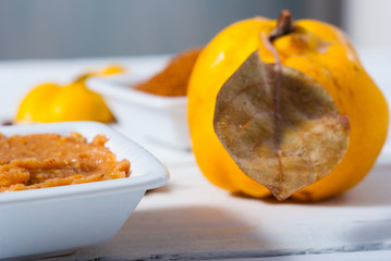 quince jelly and fruit on white wooden table background