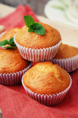 Homemade muffin on orange napkin, on the rustic background. Selective focus.