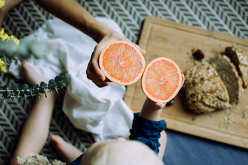 Mother and son holding halves of grapefruit. Close up hands and fruit