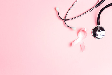 Pink ribbon and stethoscope on pink background with  copy space.