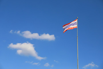 Flag of Thailand with blue sky background.