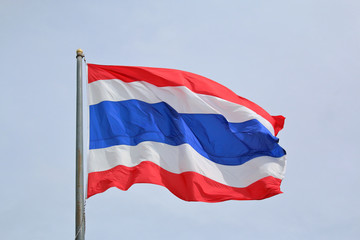 Flag of Thailand with blue sky background.