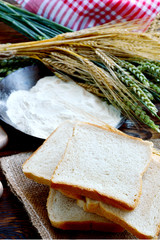 Green and Gold Wheat ears with wheat flour and White bread sliced.
Product of wheat.