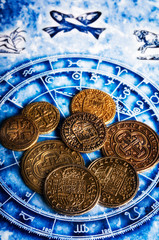 money gold coins lying on horoscope with zodiac signs like a concept astrology and wealth, abundance