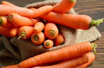 Carrots in sack bag on wooden floor.
Carrots provide a number of nutrients other than beta-carotene. They are rich in fiber.