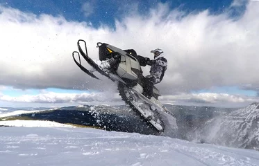 Tuinposter RIDER JUMPING WITH SNOWMOBILE BETWEEN CLOUDS © JIT