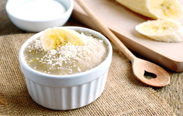Thailand traditional dessert .
Steamed Banana Cake (Thai name is Kanom Gluay) with white cup on wooden background.