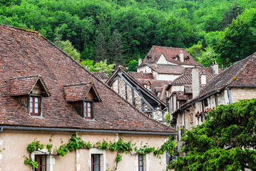 Saint Cirq Lapopie medieval village houses with green vegetation background, Lot, France