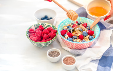 High protein healthy breakfast, buckwheat porridge with blueberries, raspberries, flax seeds and honey Closeup view, selective focus