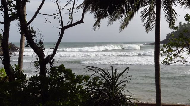 Huge surfing waves breaking at Hiriketiya beach on the south coast of Sri Lanka