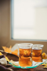 Coffee, books, yellow maple leaves at the window-the concept of comfort and warmth in autumn.