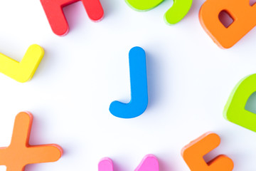 J letters in English made from wood bright colors.
