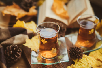 Tea in Turkish cups, books, yellow maple leaves at the window and a warm blanket - the concept of...