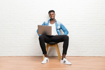 Afro american man working with his laptop posing with arms at hip