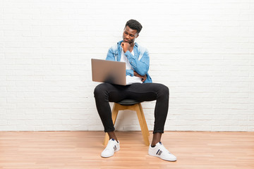 Afro american man working with his laptop standing and looking down
