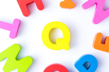 Q letters in English made from wood bright colors.