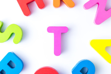 T letters in English made from wood bright colors.