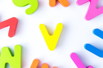 V letters in English made from wood bright colors.