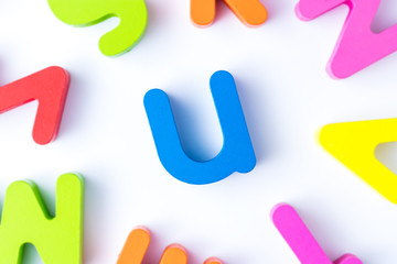 U letters in English made from wood bright colors.