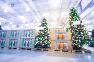 Blurred tall and large Christmas tree and supplies display at hypermarket in USA