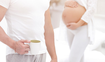 closeup of husband and pregnant wife ,standing in the new living room