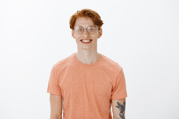 Pleased to meet you. Smart attractive redhead man with freckles and tattoos, smiling with friendly...